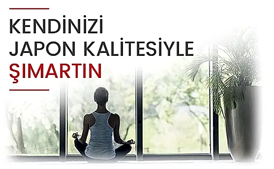 Bir kız, arkası dönük, yoga yaparken, büyük cam pencereden doğa manzarasına bakar, sakin ve huzurlu bir görüntü.