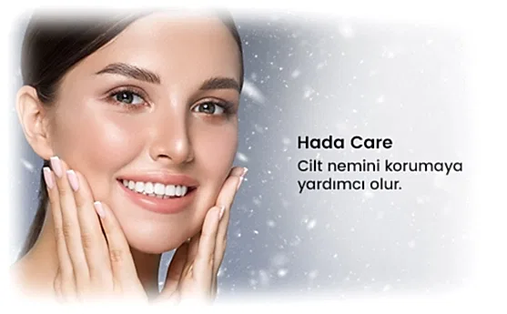 Gülümseyen kadın, yanaklarına dokunarak cildini nemlendiren cilt bakım ürününü kullanıyor.